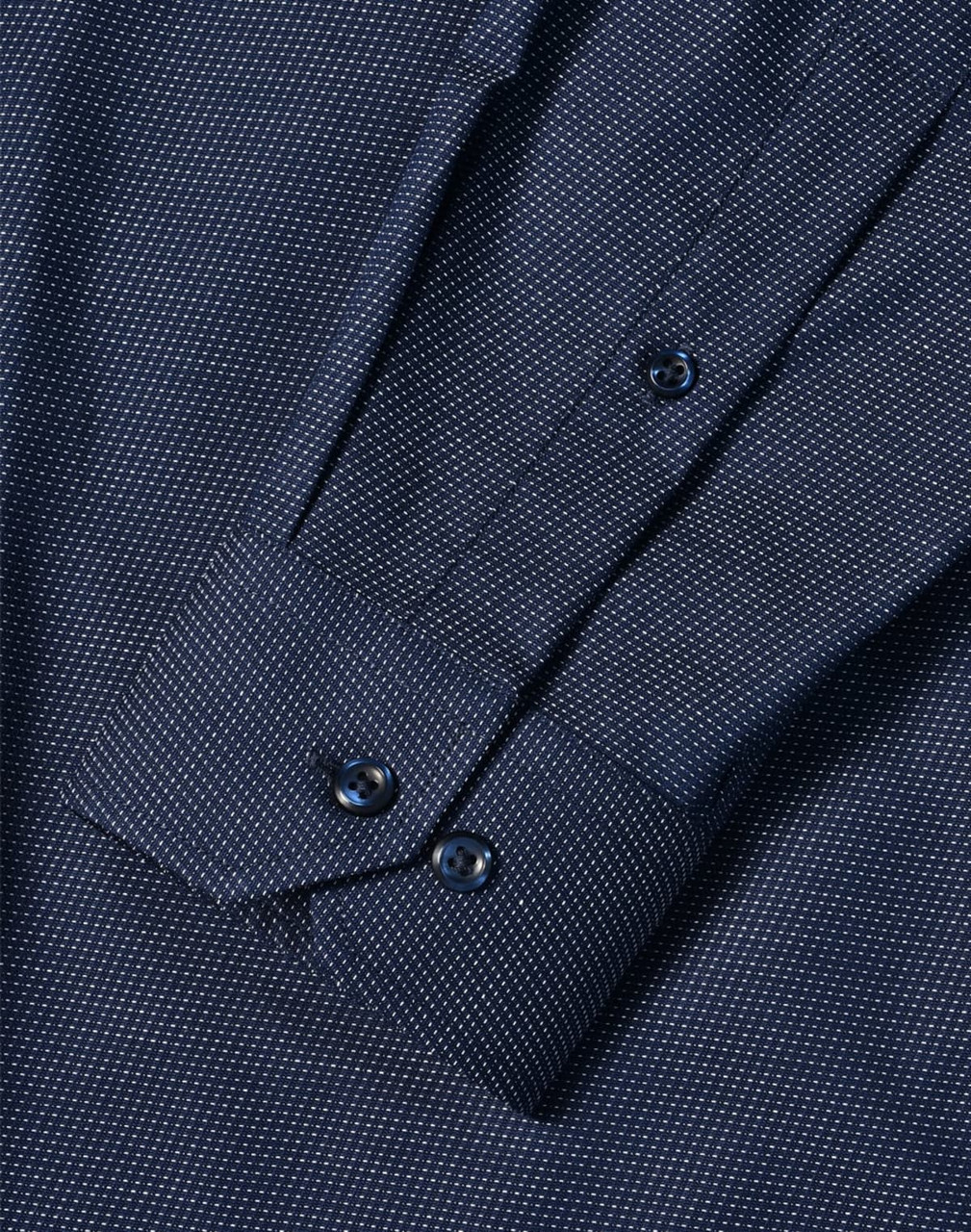 A men's long sleeve button-up shirt in navy with a pin dot pattern and cuff details. Features a logo.