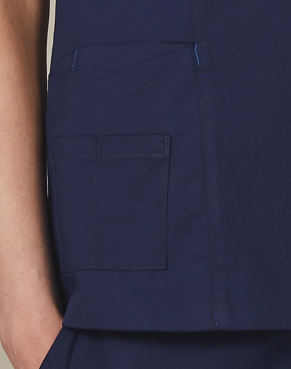 A deep navy scrub top featuring a pocket detail and contrast stitching. Includes a small logo on the garment.