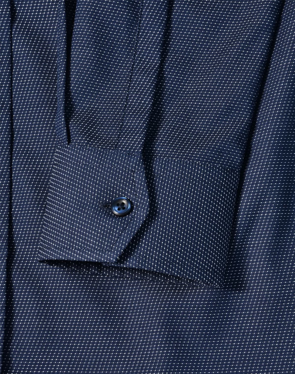 A navy blue pin dot stretch long sleeve shirt with a buttoned cuff and a branded logo.
