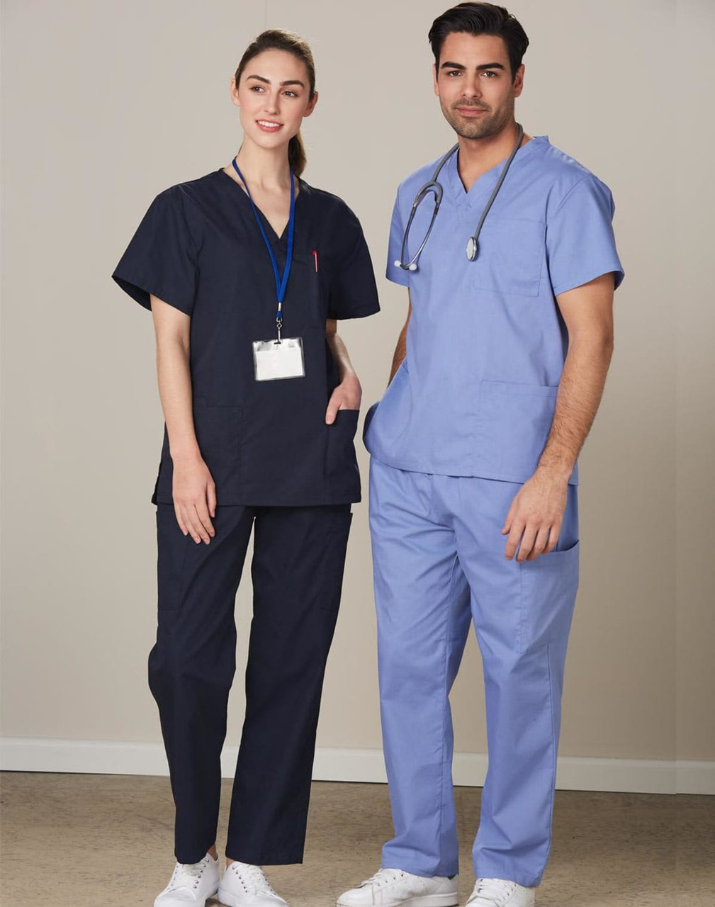 Unisex scrub pants in navy blue, worn by a male and female model, featuring a logo on the garment.