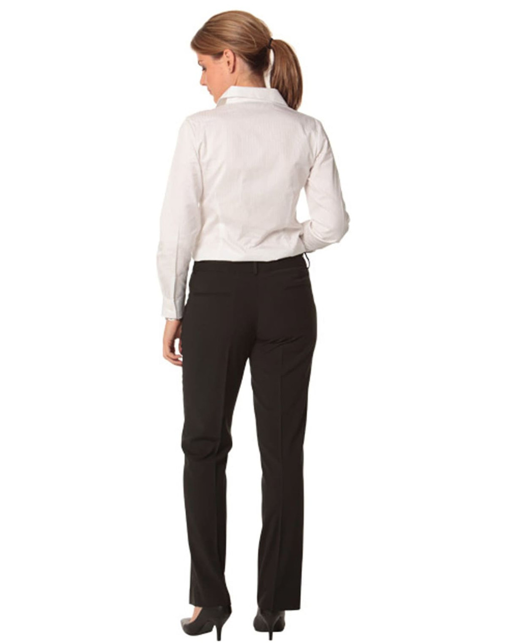 A woman wearing black slim leg pants with a flexi waist, paired with a white shirt, seen from the back.