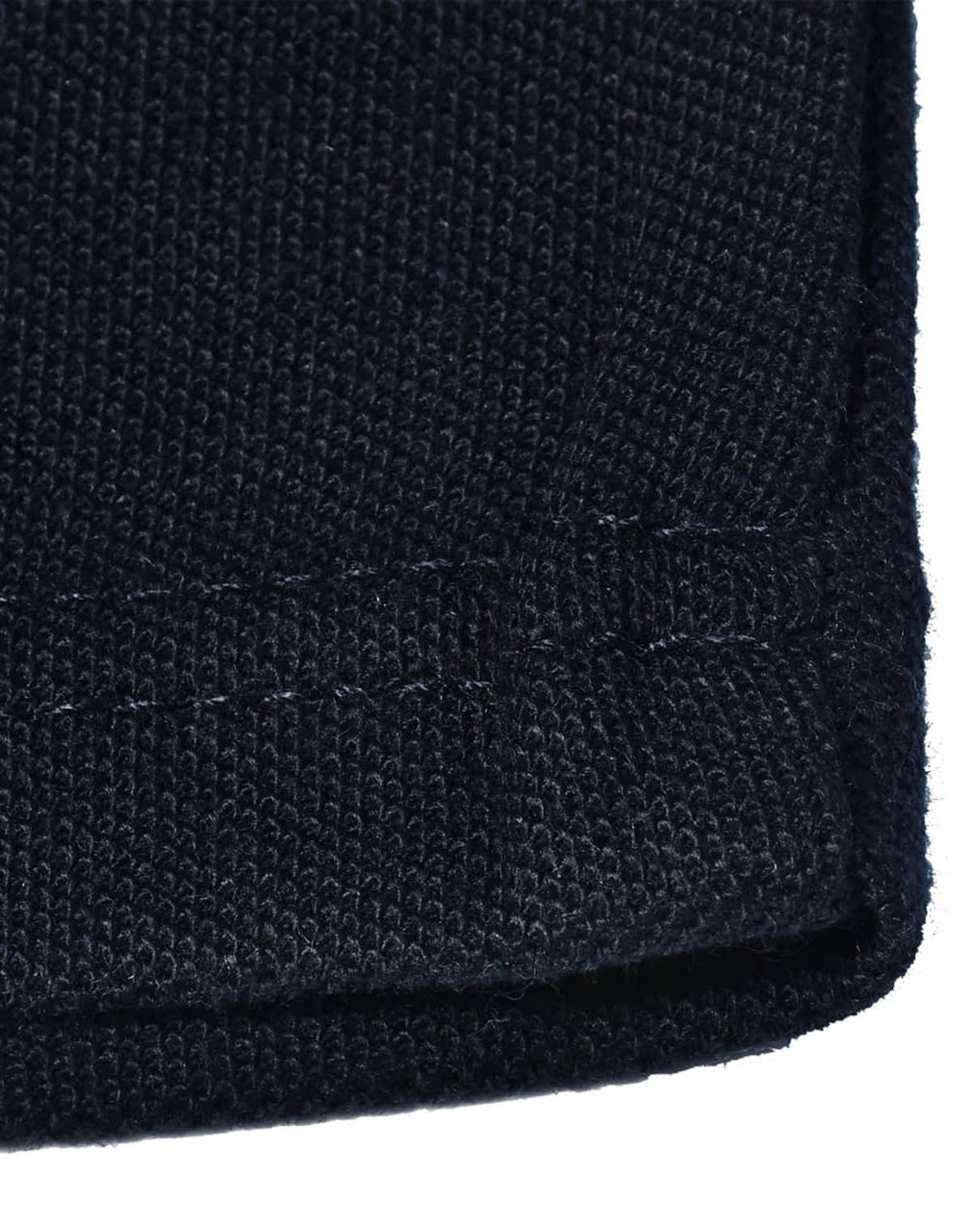 A close-up of a dark navy knit fabric with a hemmed edge, showcasing the texture and stitching details.