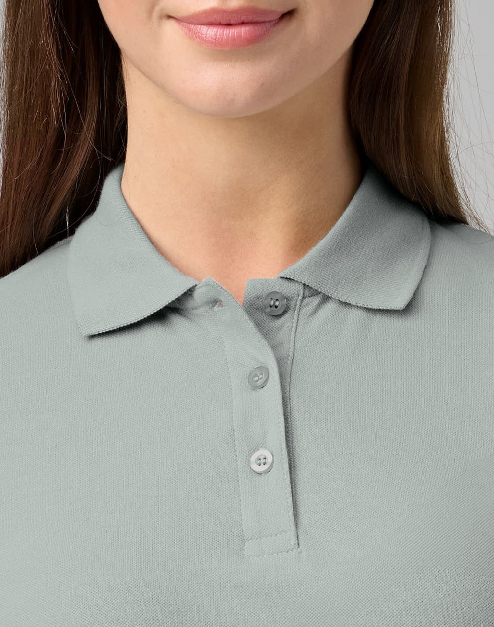 A close-up of a woman's light grey cotton stretch polo shirt with a collared neck and three buttons.