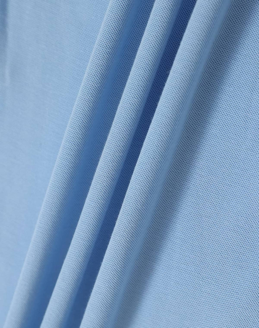 A close-up of light blue fabric, showcasing the texture and folds of a polo shirt material.