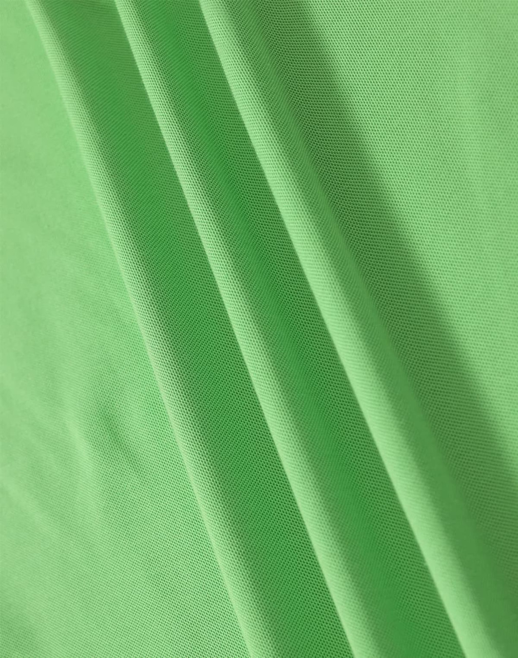 A close-up of soft, textured fabric in vibrant green, showcasing the material of a polo shirt.