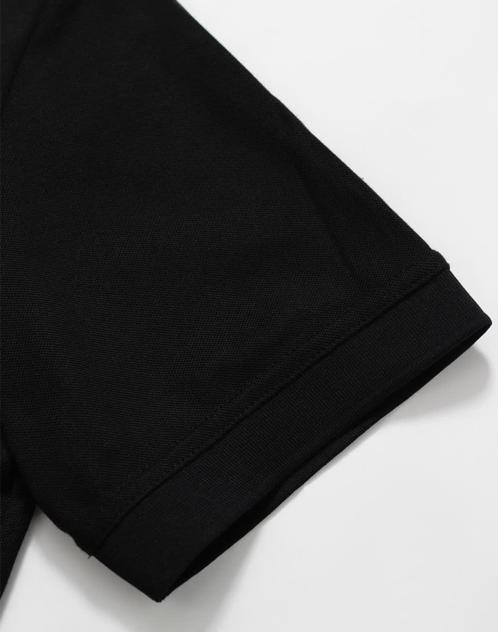 A black Men's Truedry Pique Polo shirt showcasing the sleeve detail. The shirt features a logo.