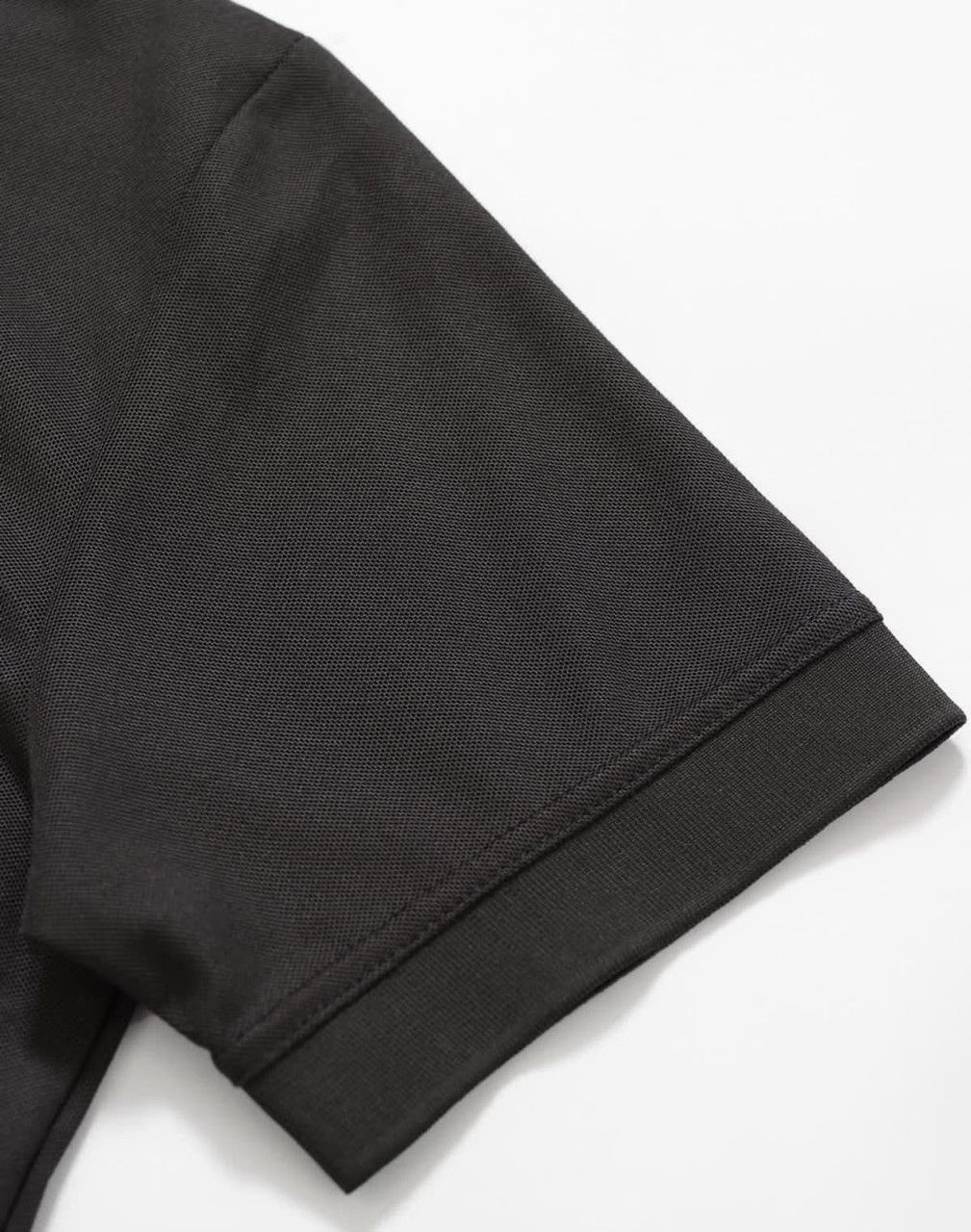 A black polo shirt featuring a smooth fabric texture and neatly finished sleeve hem. It also has a logo.