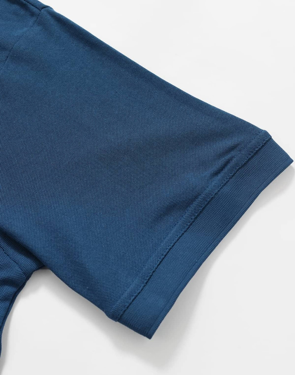 A close-up of a blue polo shirt sleeve with a smooth texture and cuff detail, featuring a logo.