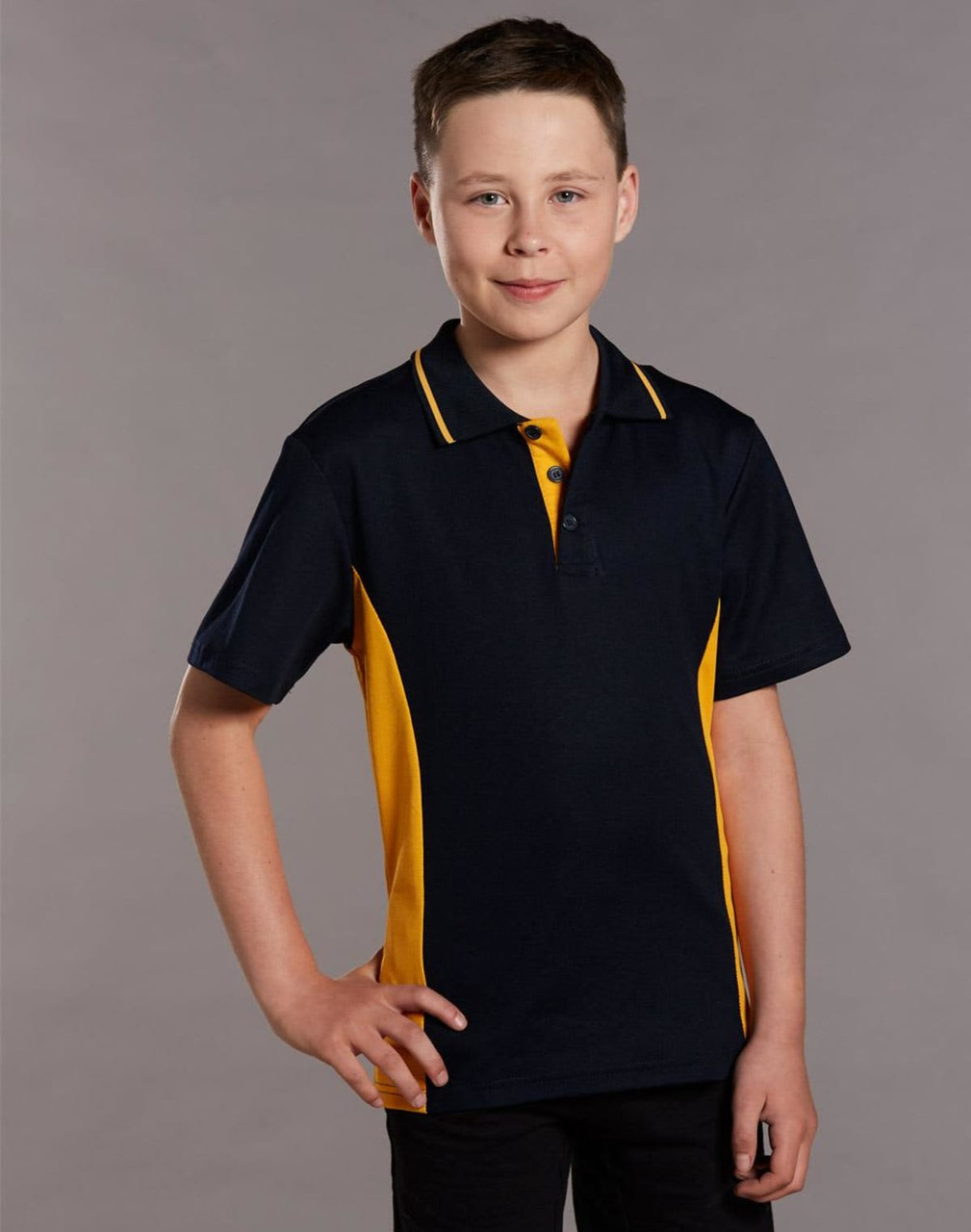 A young boy models a navy and gold contrast polo shirt, featuring a classic collar and a logo.