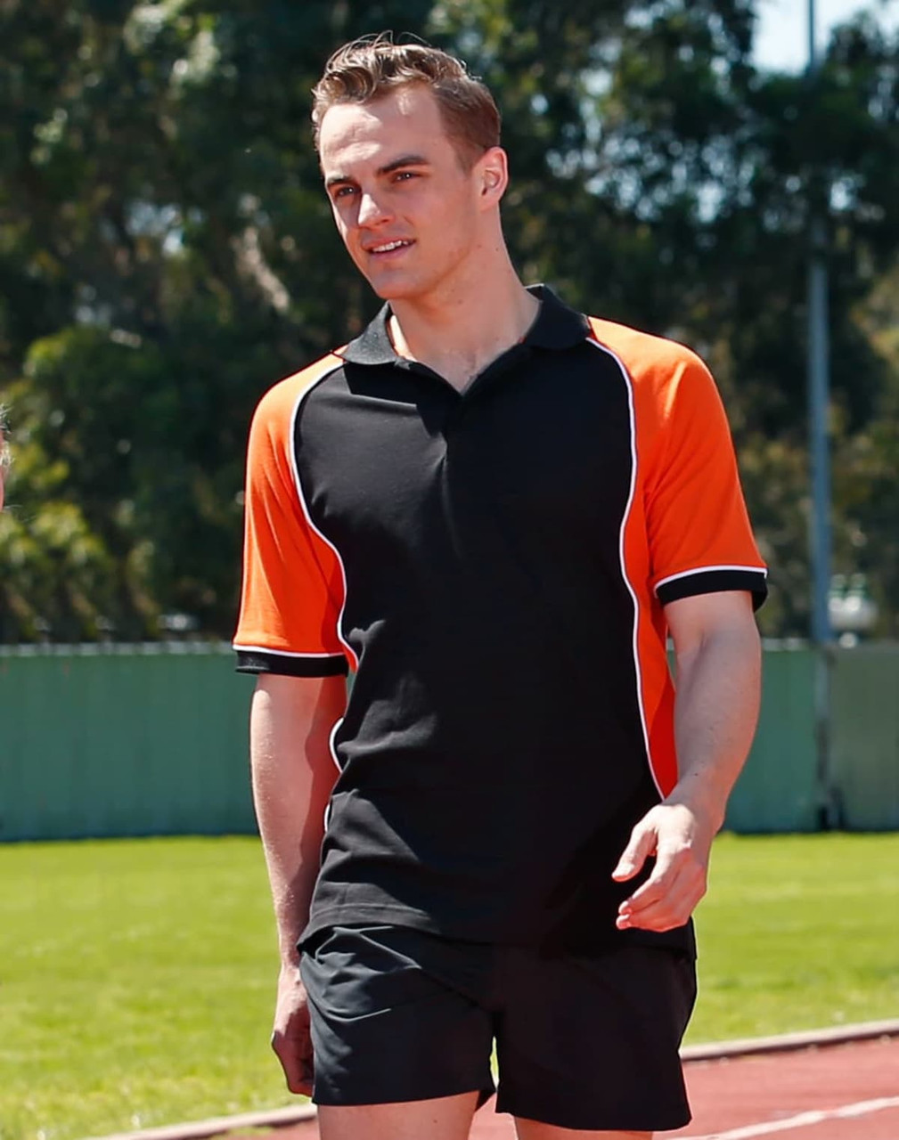 Men's TrueDry Tri-colour S/S Pique Polo in black and orange, featuring a contrasting design and a logo.