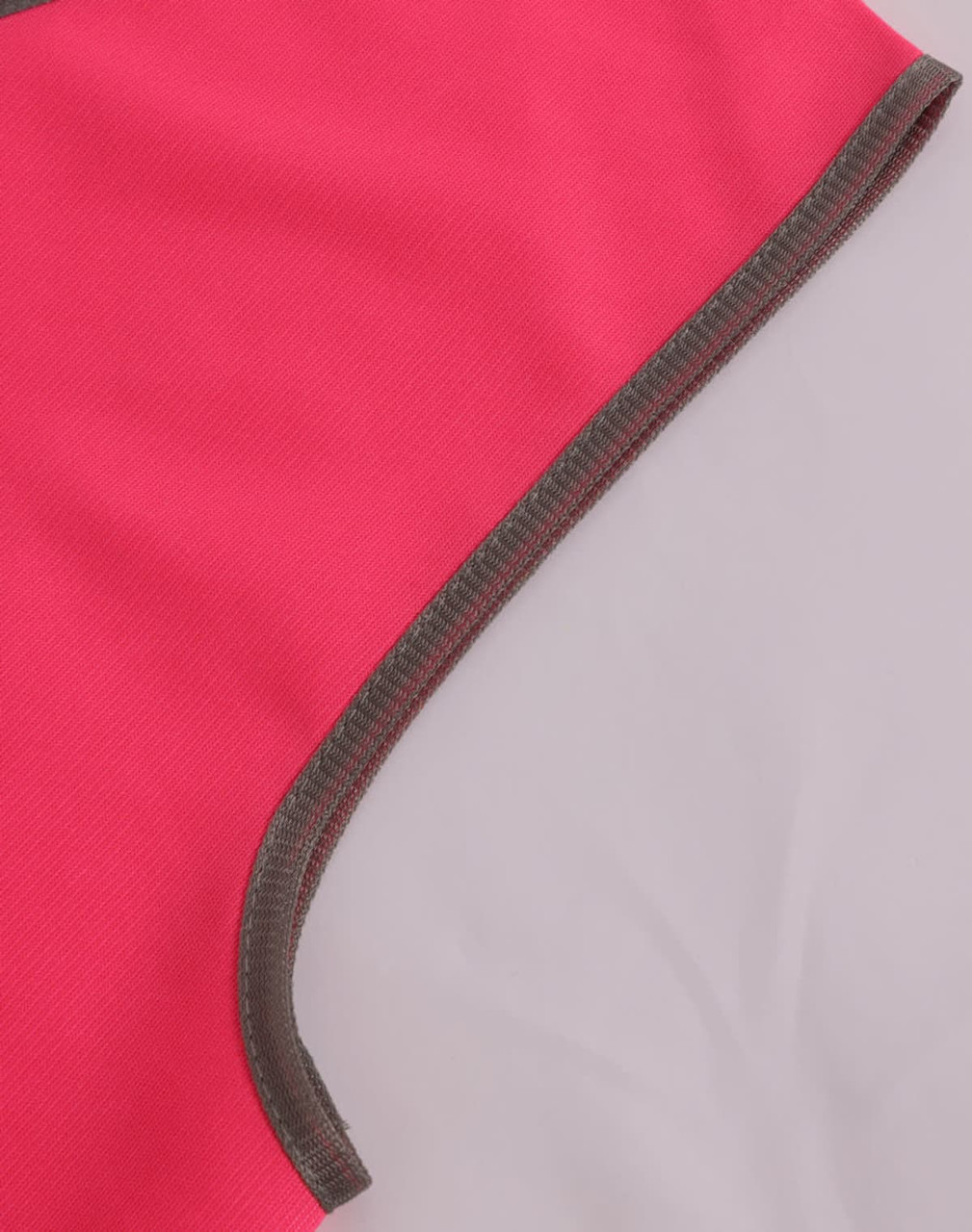 A bright pink safety vest with contrasting grey trim, featuring a smooth, durable fabric. It has a logo visible.