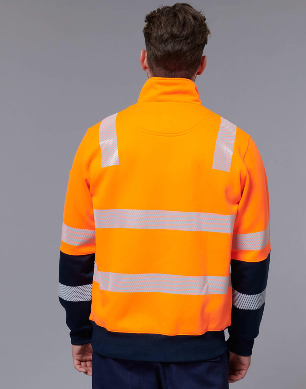 A bright orange safety jumper with reflective stripes and a navy blue collar worn from the back. It features a logo.