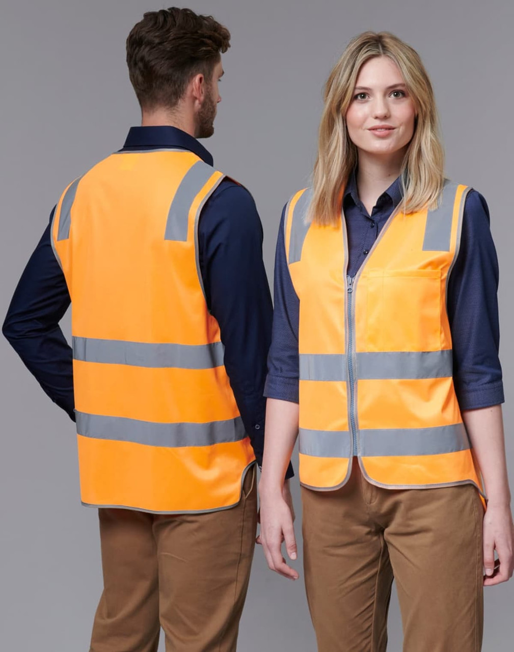 A fluorescent orange safety vest with reflective stripes, shown worn by two models from front and back.