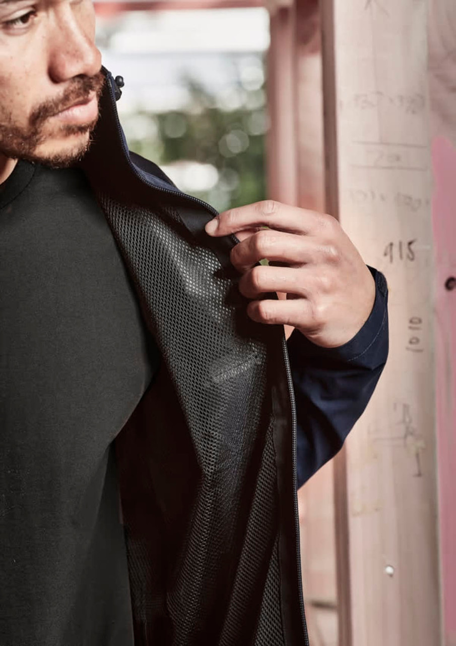 A navy unisex waterproof jacket with a mesh interior, showcased by a person holding back the fabric.