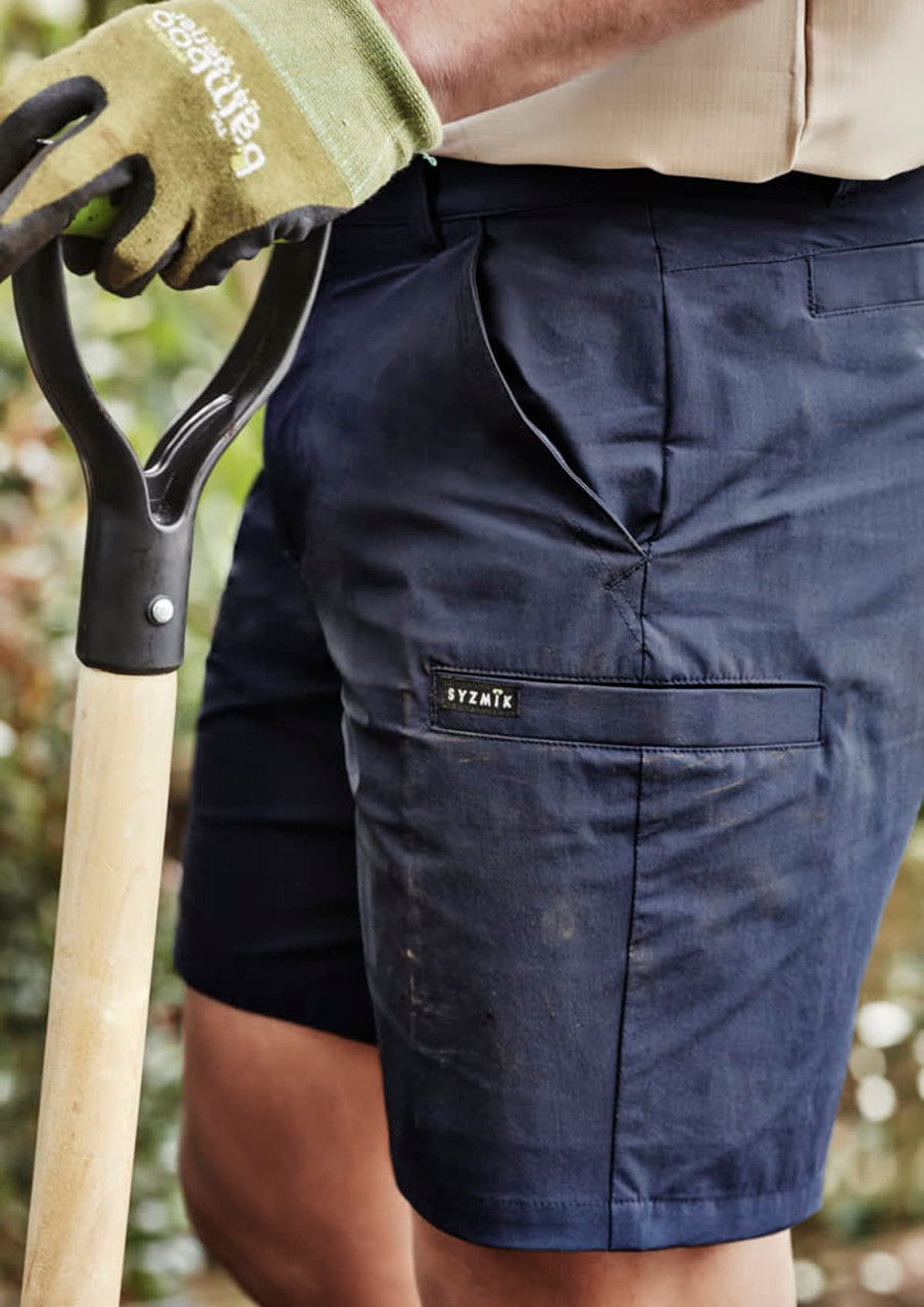 Mens lightweight outdoor shorts in navy blue, featuring a side pocket and a logo, paired with a gardening tool.