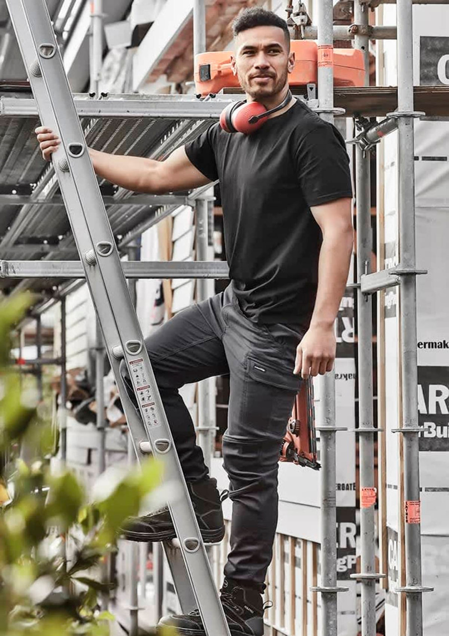 Men's Streetworx Comfort Pant in black, featuring pockets and a branded logo, worn by a man on a ladder at a worksite.