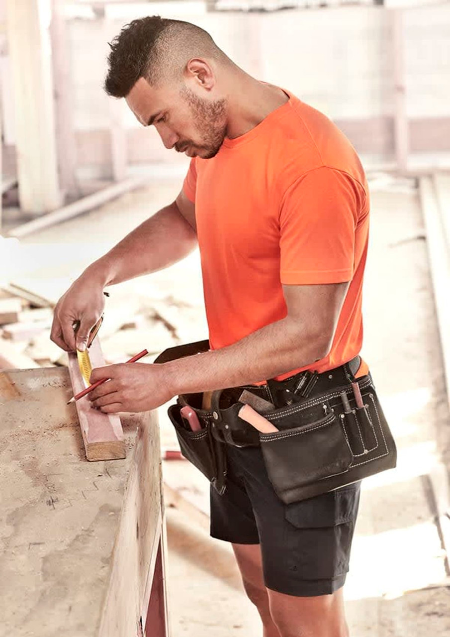 A men's high visibility t-shirt in bright orange, worn by a tradesman measuring wood, with a tool belt.