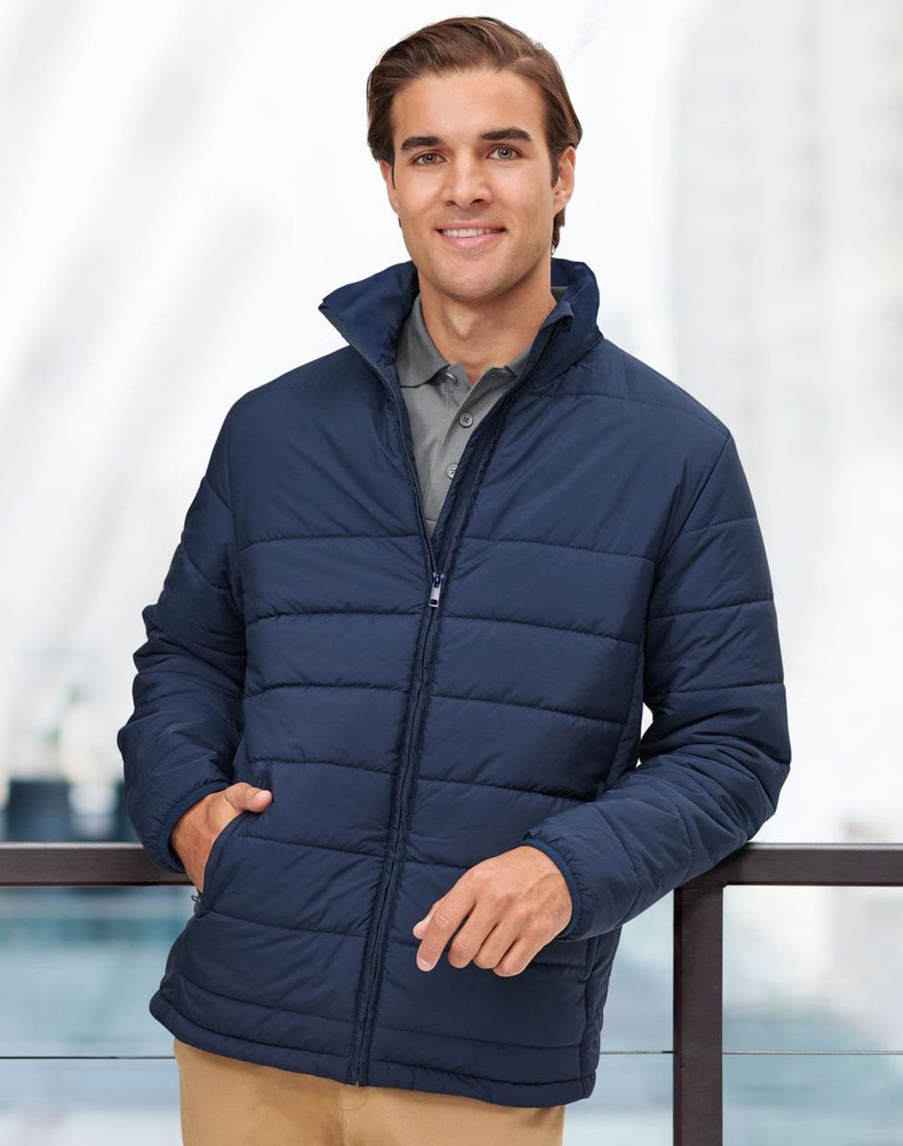 A navy insulated puffer jacket with a zip front and high collar, featuring a logo on the chest.