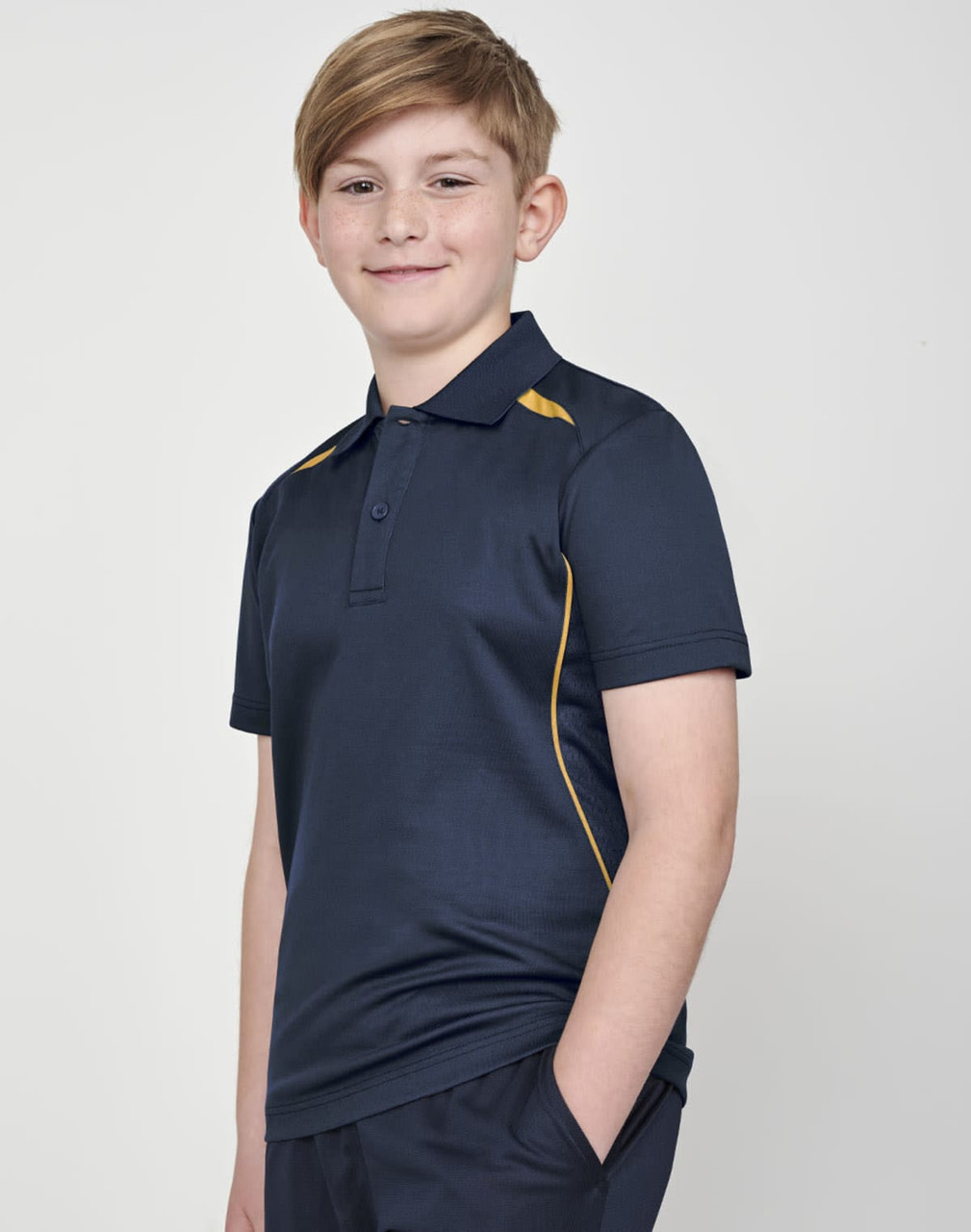 A boy wearing a navy polo shirt with yellow contrast trim and a logo on the chest.