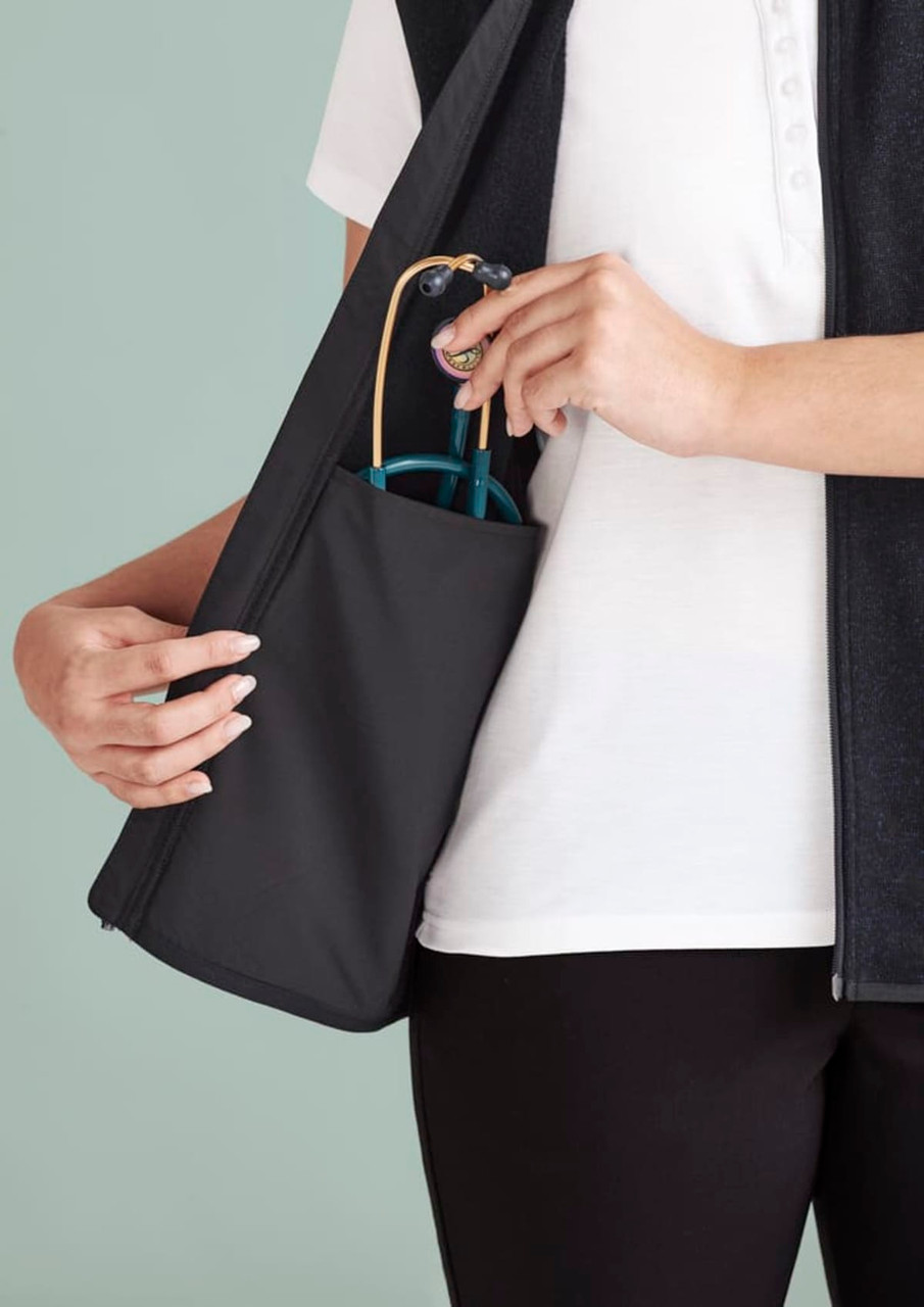 A person holds a black vest with a side pocket, featuring blue sunglasses. The vest has a zip front and a sleek design.