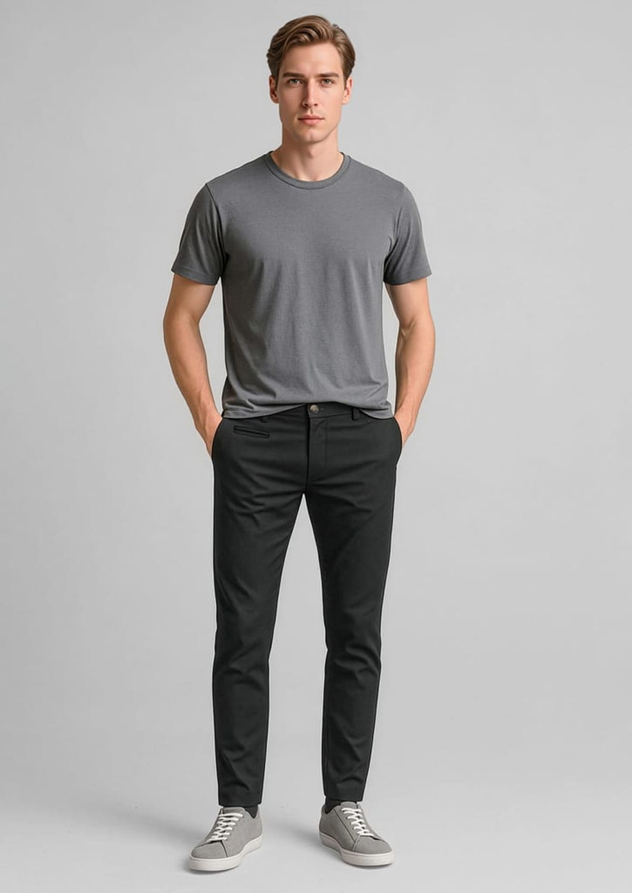 A model wearing black tapered stretch chino pants paired with a grey t-shirt and grey sneakers.
