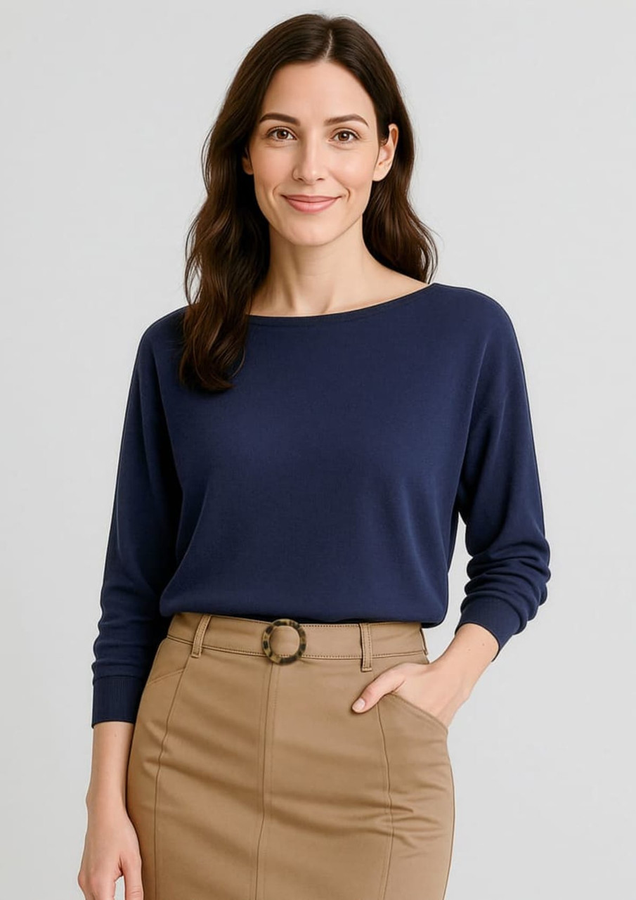 A navy batwing sweater top on a model, paired with a tan skirt. The image features a logo on the clothing.