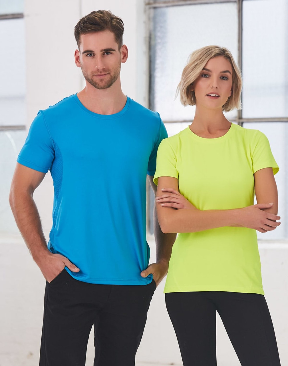 A blue men's t-shirt and a neon yellow women's t-shirt, both featuring a logo, displayed against a light background.