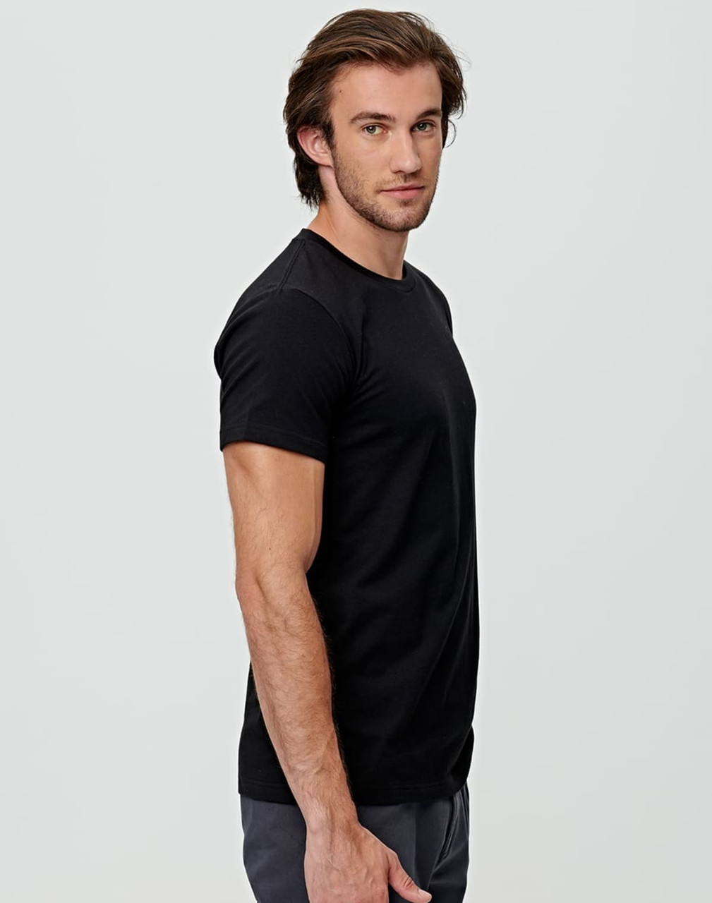 A black premium cotton men's T-shirt displayed on a model, showing a side view. The shirt features a logo.