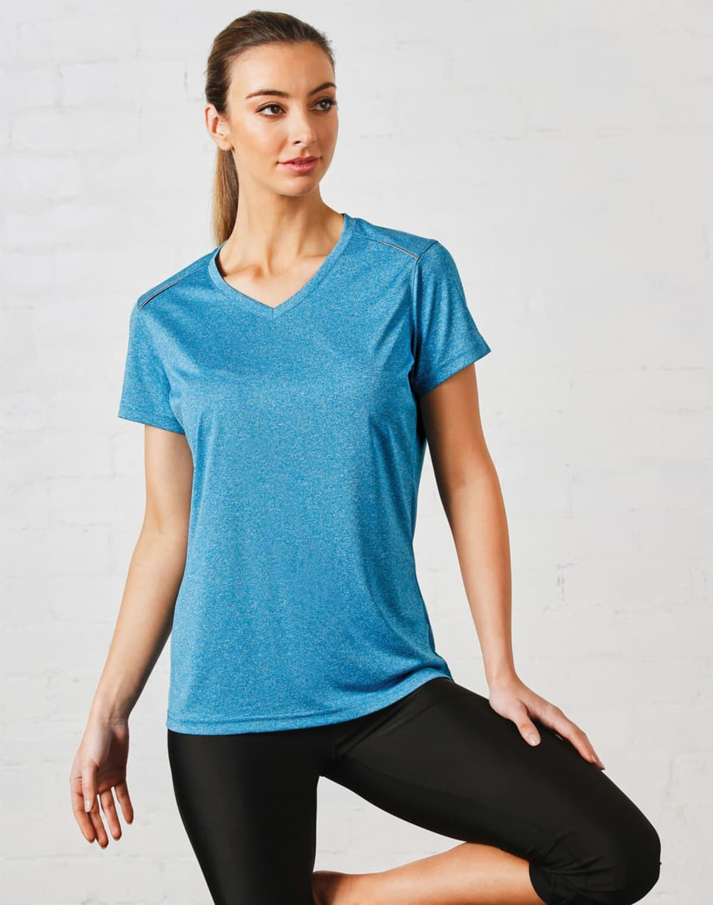 A blue short sleeve tee with a v-neck design, featuring a logo on the front, paired with black athletic pants.
