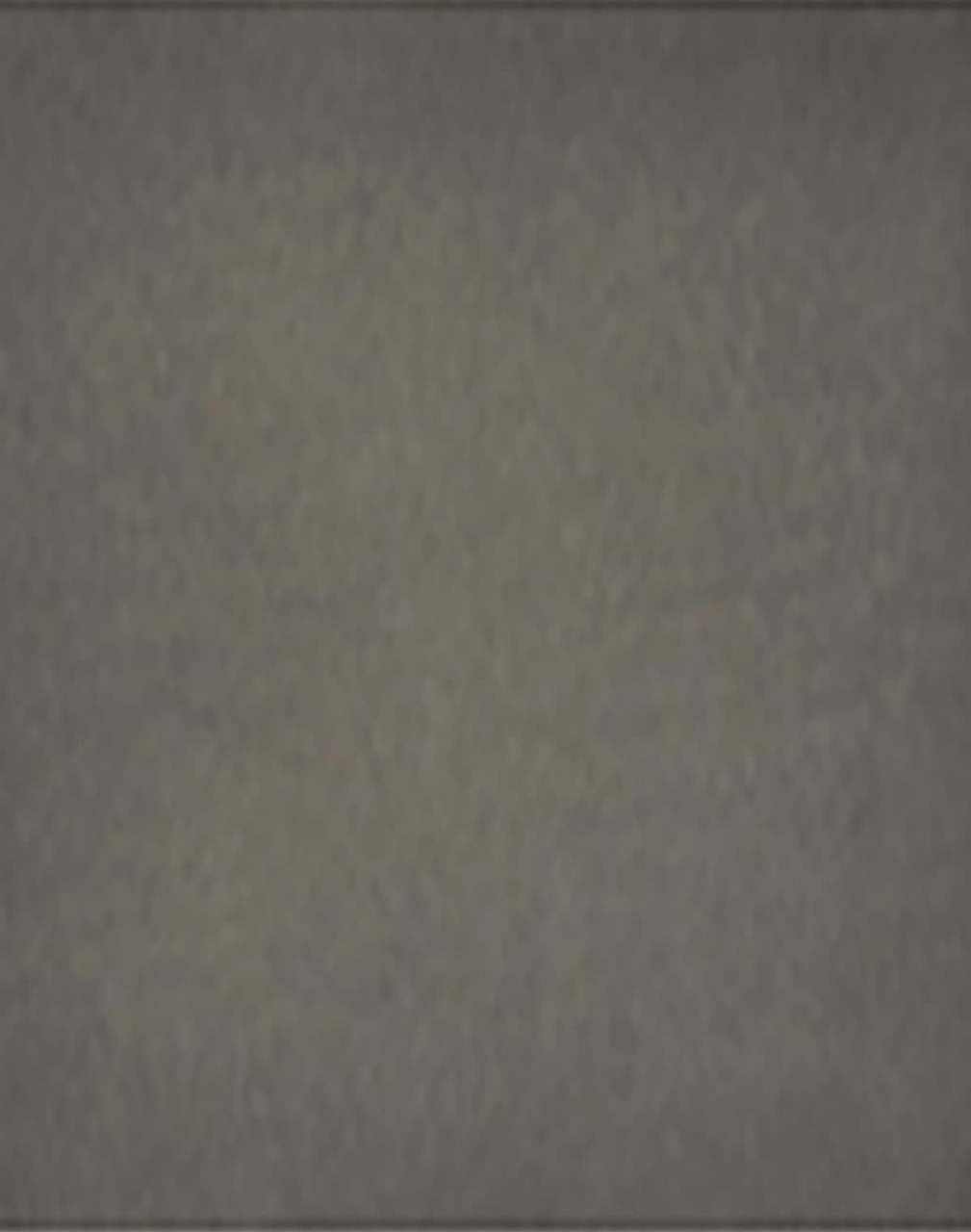 A grey removable knee pad with a branded logo. The surface appears textured and durable for various applications.