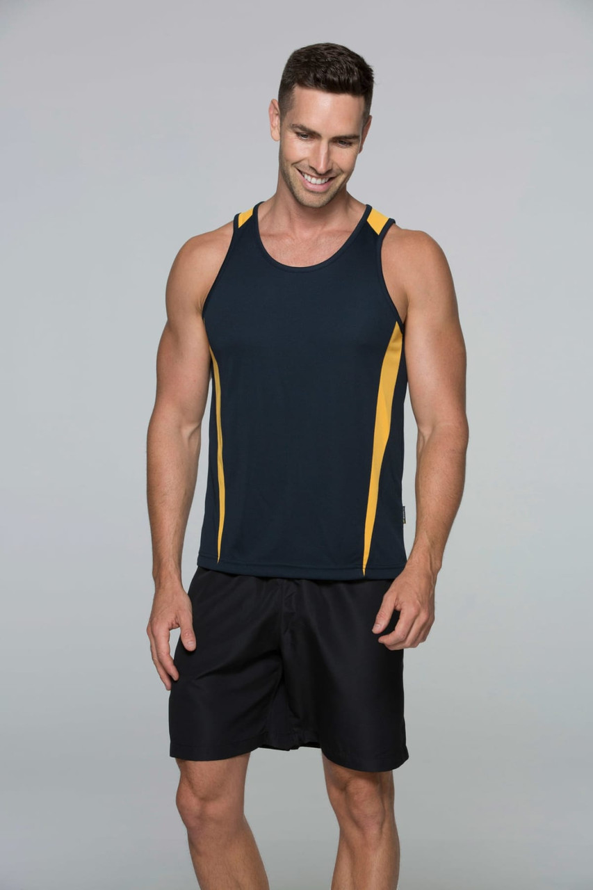 A man wearing a sleeveless black and gold singlet, paired with black shorts, smiling at the camera.