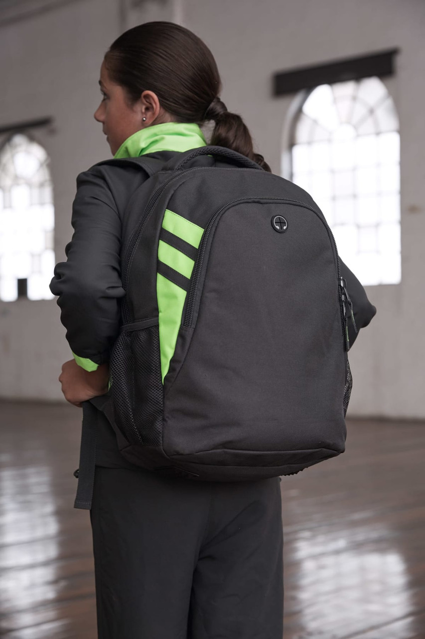 A black backpack with neon green accents is worn on a person's back, showcasing its sleek design.