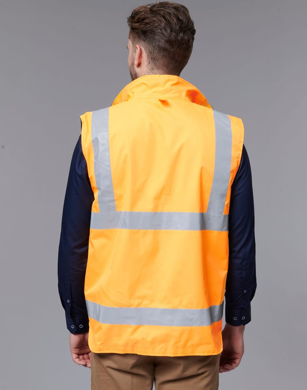 A reversible safety vest in bright orange with reflective stripes, viewed from the back. It has a logo on the fabric.
