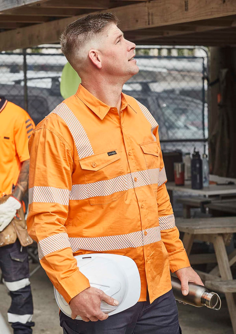 An orange long-sleeve work shirt with segmented reflective tape, featuring a pocket and a branding logo.