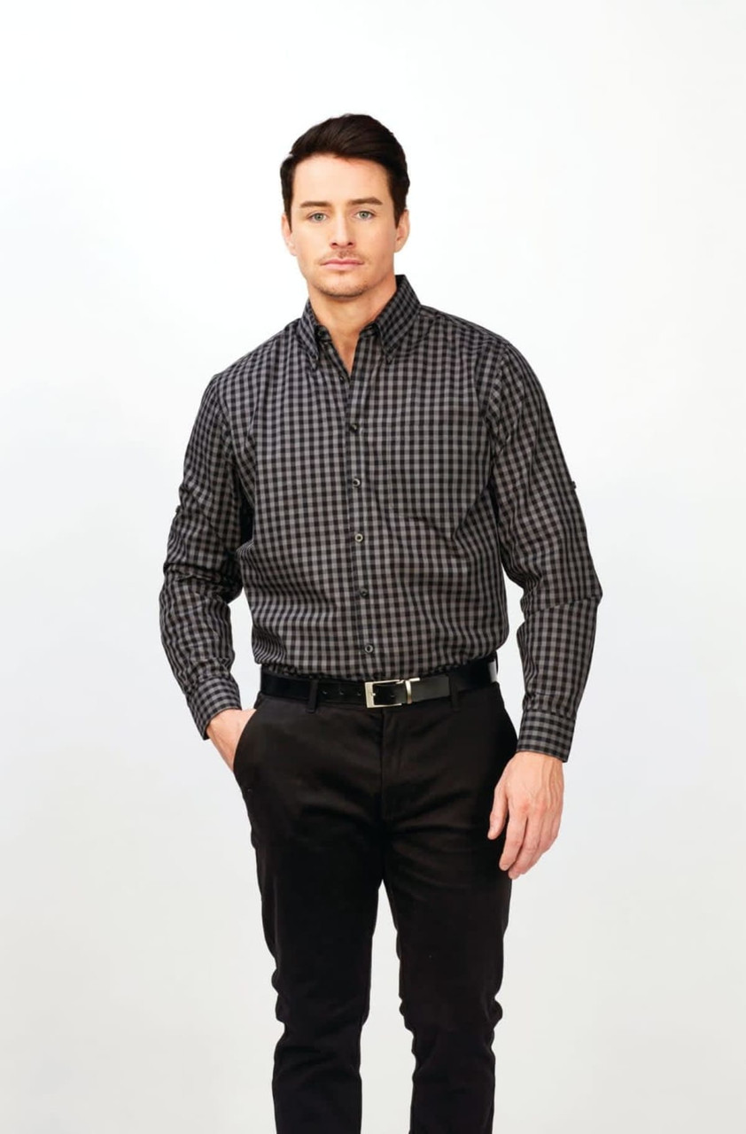 A long sleeve shirt in a black and grey checkered pattern, featuring a logo, worn by a model with dark hair.