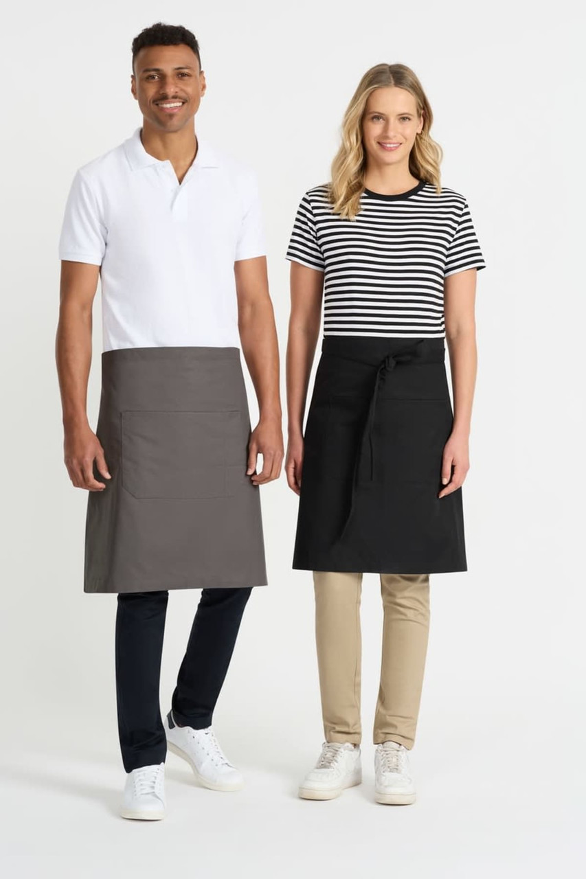 Two models wearing aprons, one in grey and the other in black, standing side by side. Both models are dressed in casual attire.