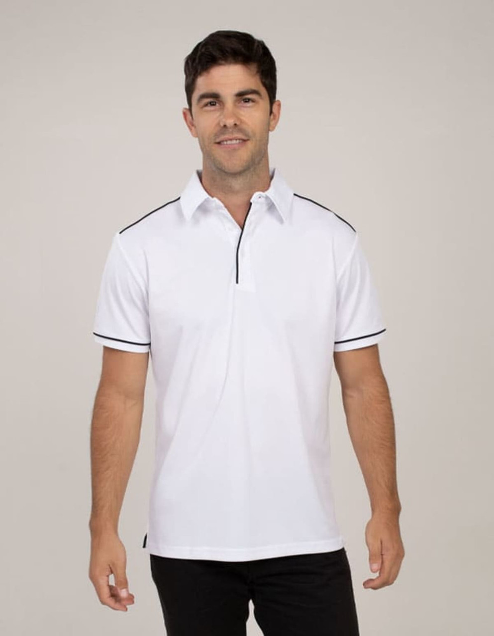 A white polo shirt with black trim, featuring a collar and a zippered neck, modelled by a man standing against a neutral background.