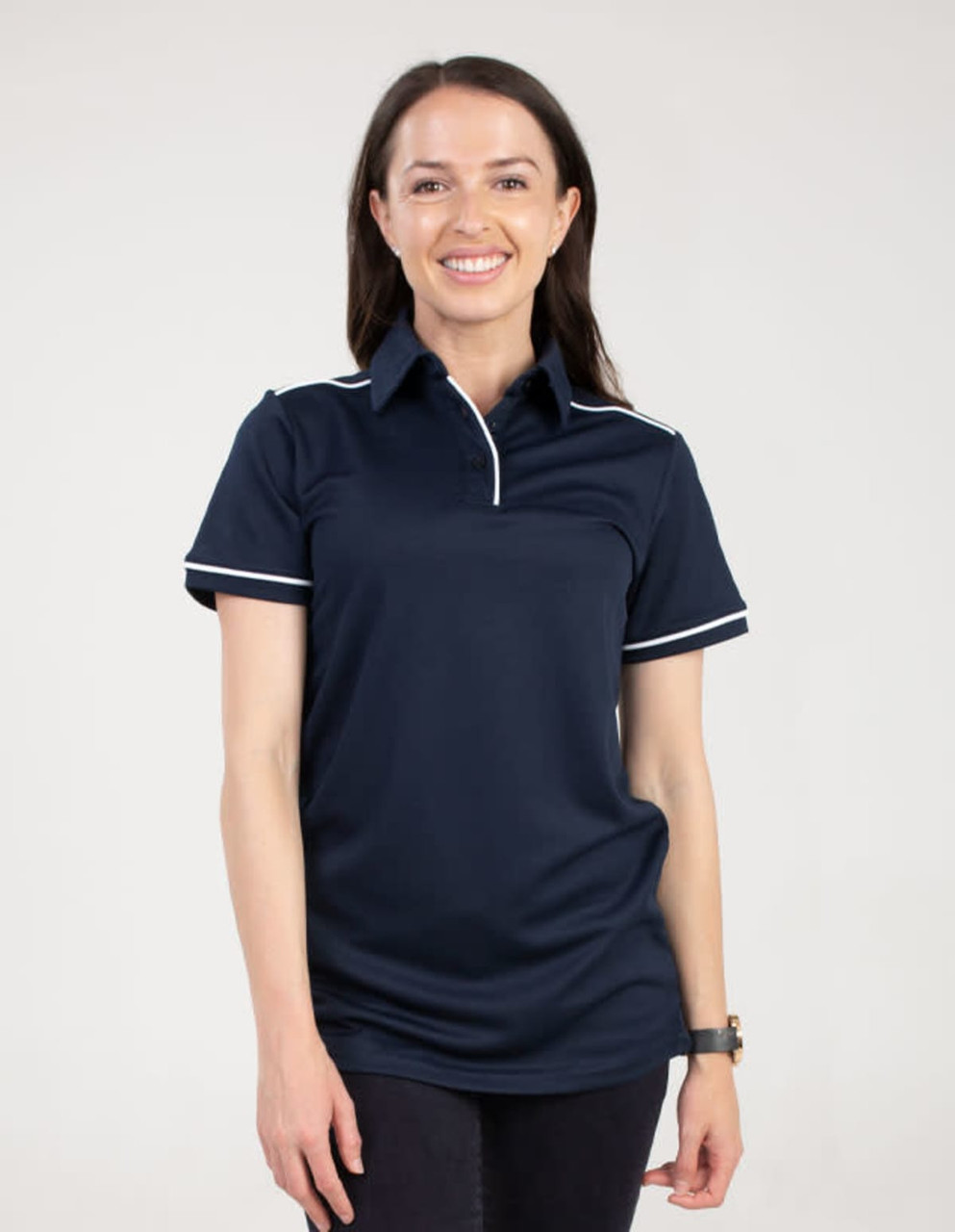 A navy polo shirt with white trim, displayed on a model smiling. The shirt features a collar and a logo.