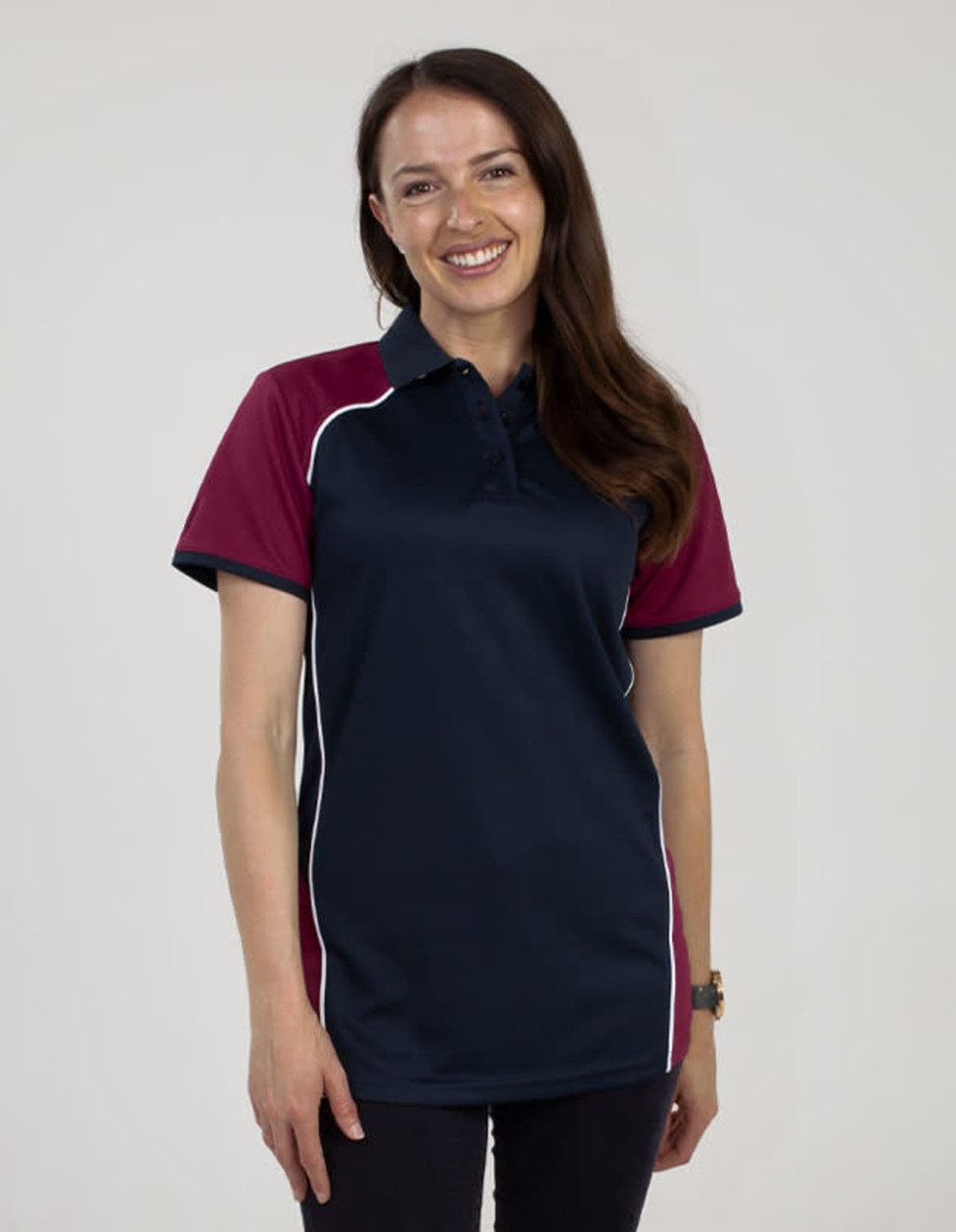A woman wearing a navy and maroon polo shirt featuring a logo. The shirt has short sleeves and white piping.