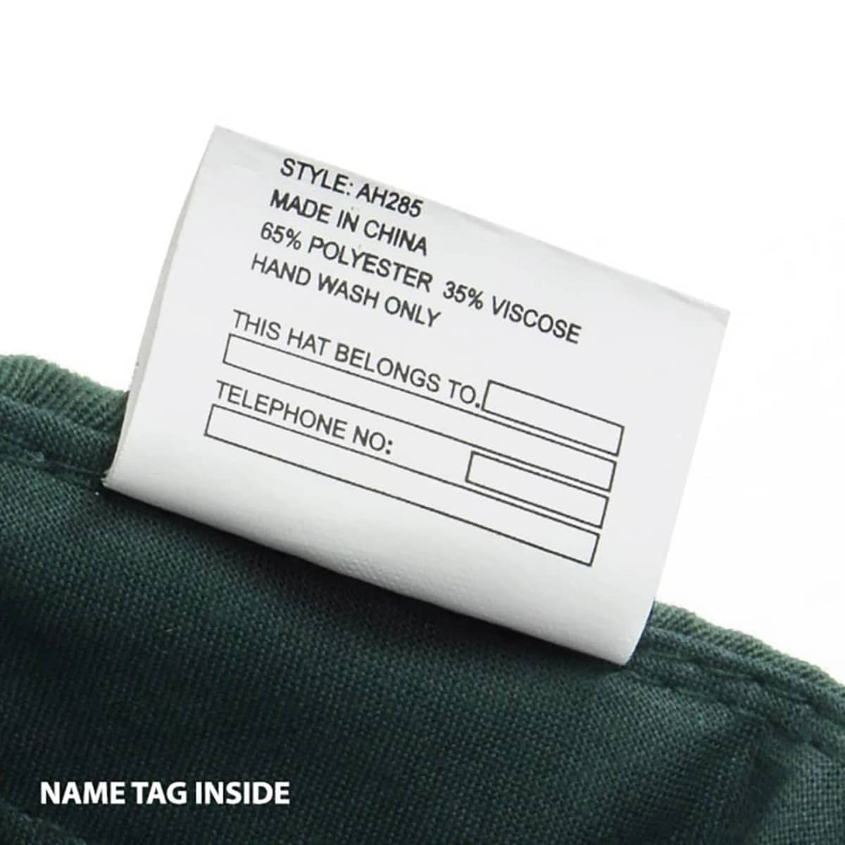 A green cap with a label featuring washing instructions and space for a name tag.