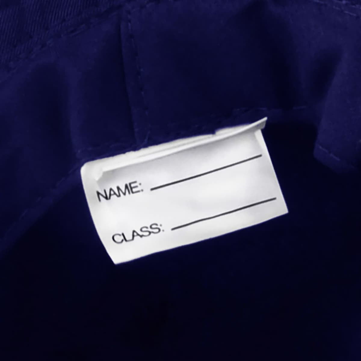 A navy blue bucket hat featuring a label for name and class identification. The hat has a branding logo.