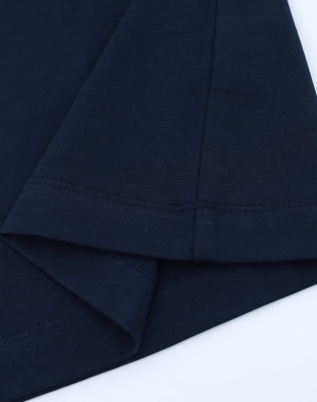 A navy blue long-sleeve cotton tee shirt featuring a hemmed finish and a logo on the sleeve.