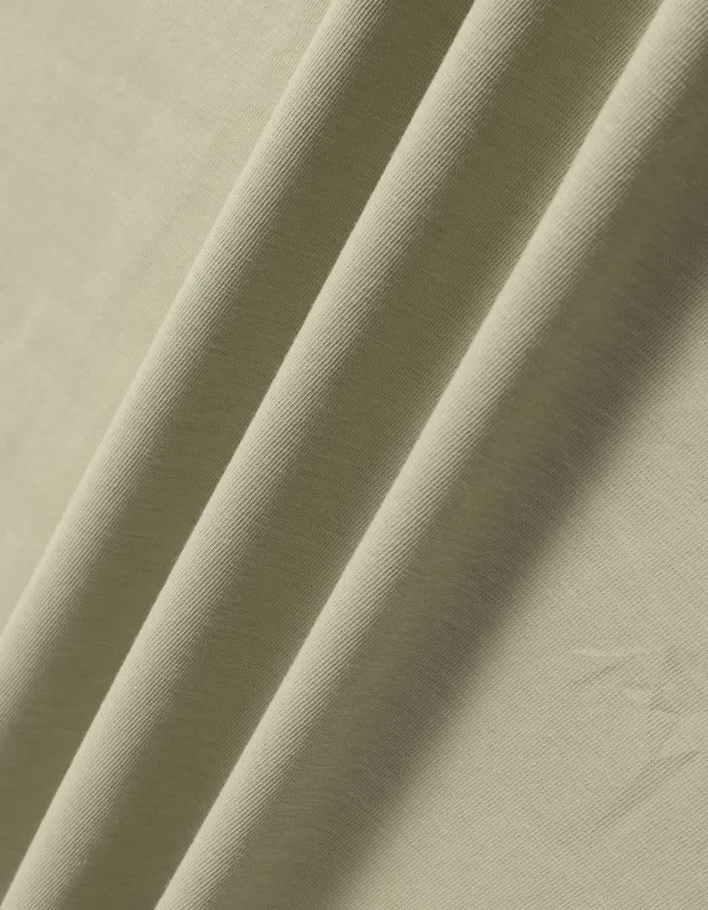 A close-up of soft, folded fabric in a muted green shade. The material has a smooth texture.