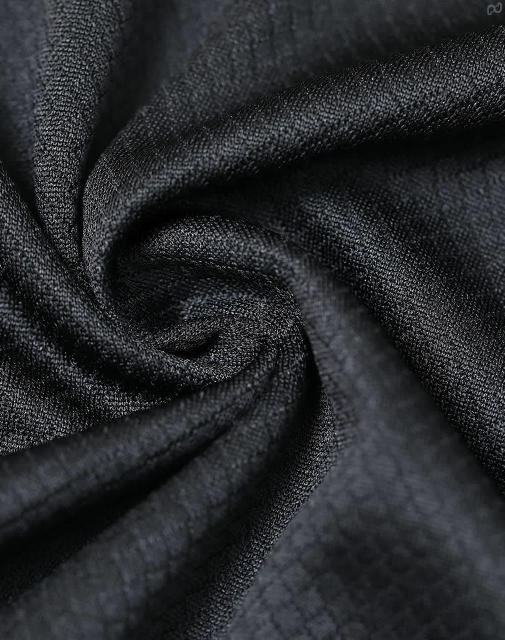 A close-up of black jacquard knit fabric, featuring a textured pattern and a subtle sheen, ideal for polo shirts.