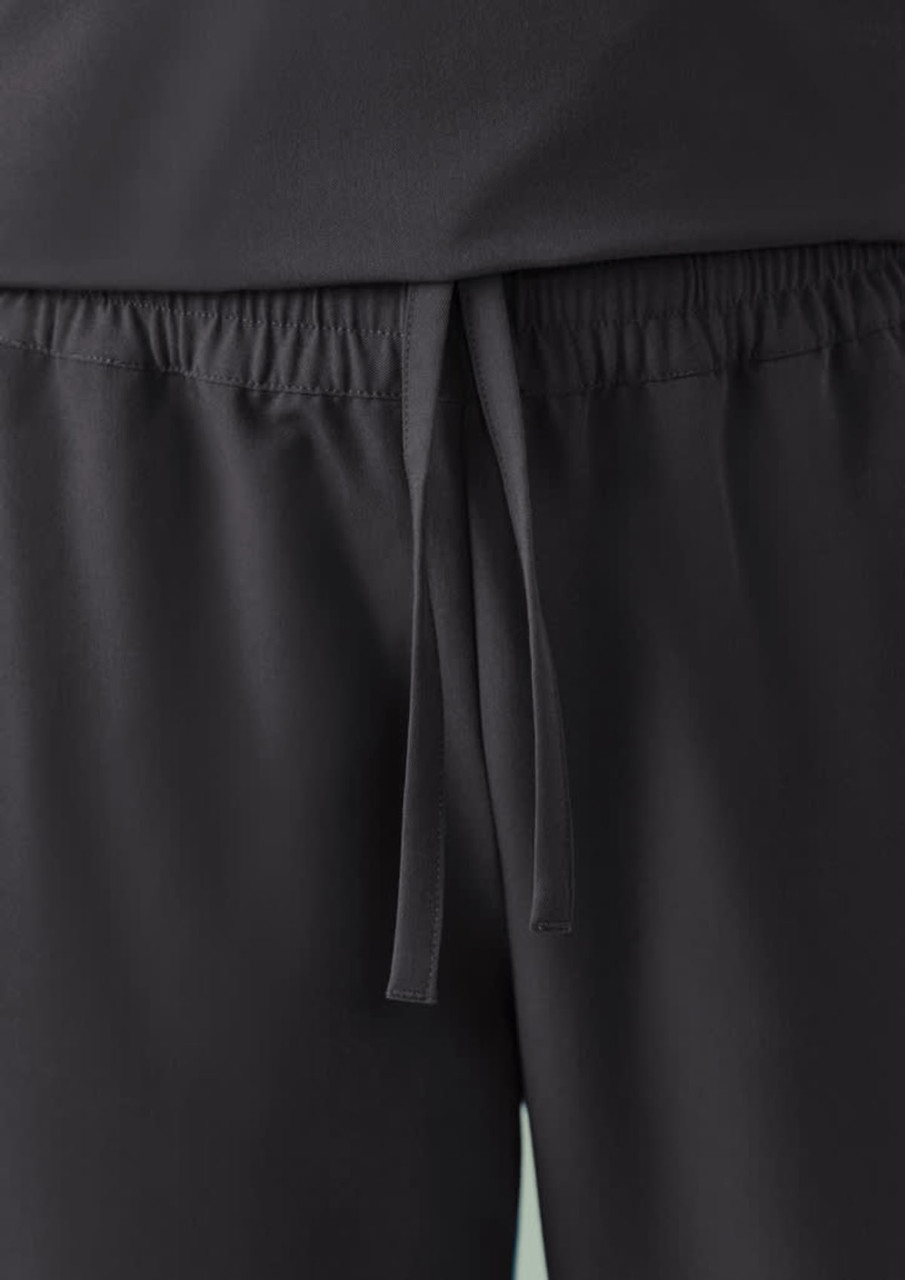 Unisex straight leg scrub pants in black, featuring an elastic waistband with a drawstring. includes a logo.
