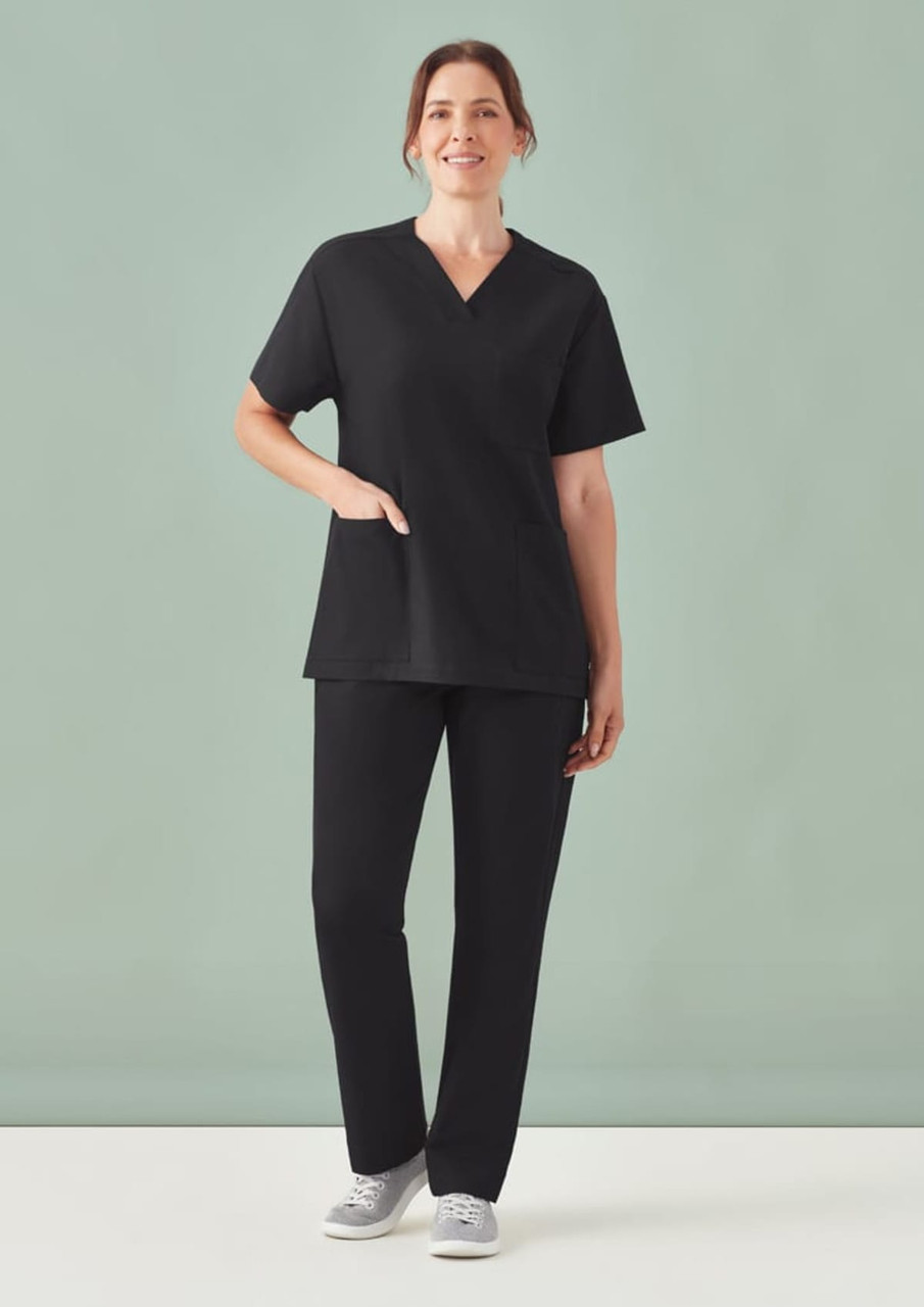 A unisex black V-neck scrub top with short sleeves, paired with matching black pants, styled casually.