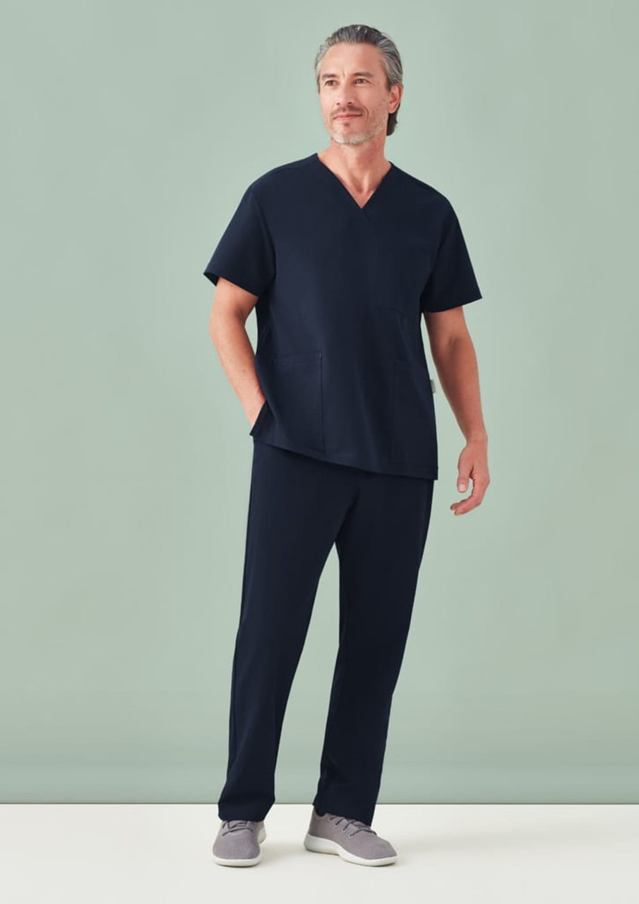 A unisex pulse V-neck scrub top in navy blue worn with matching scrub pants, featuring a logo.