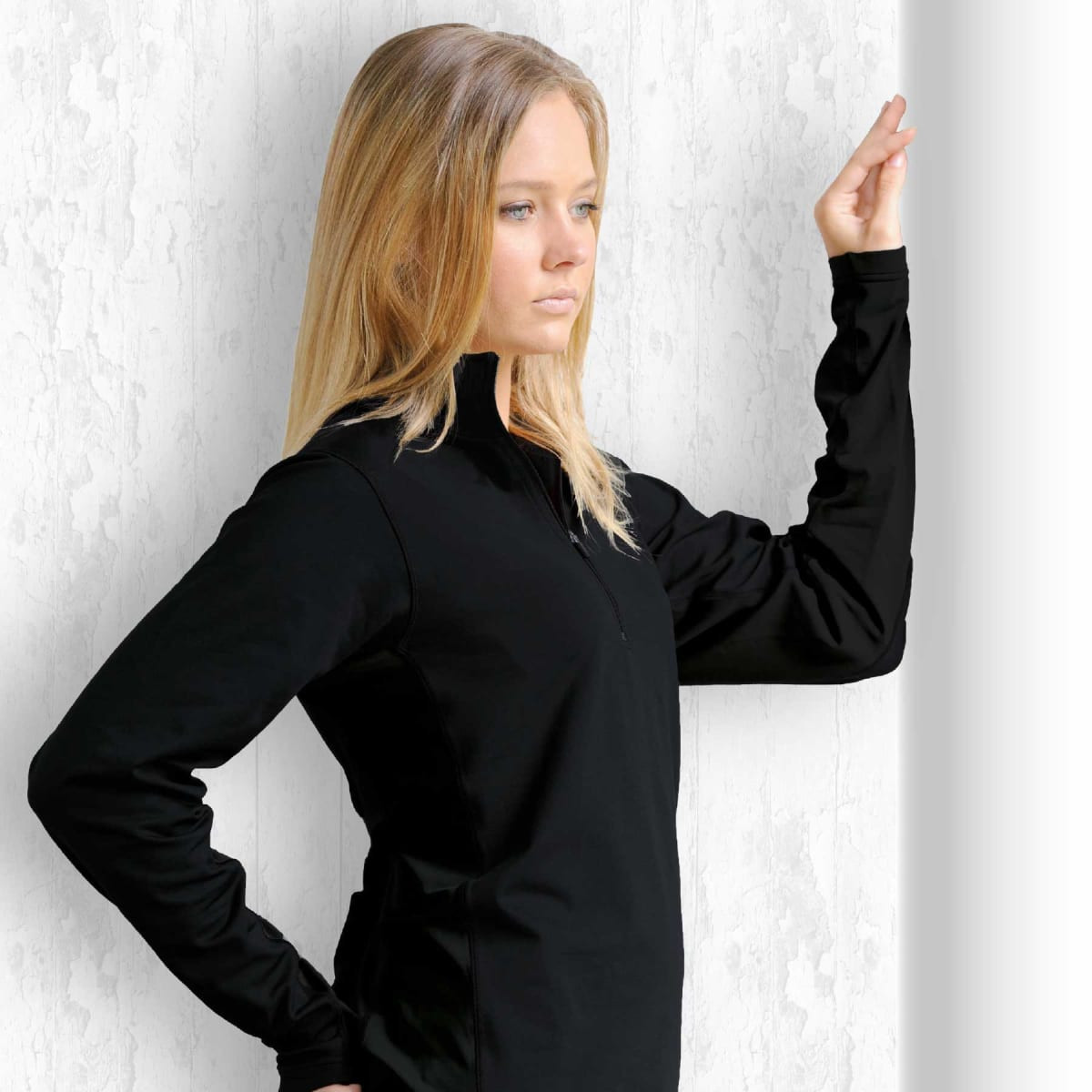 A black long-sleeve top with a zip collar displayed against a textured background.