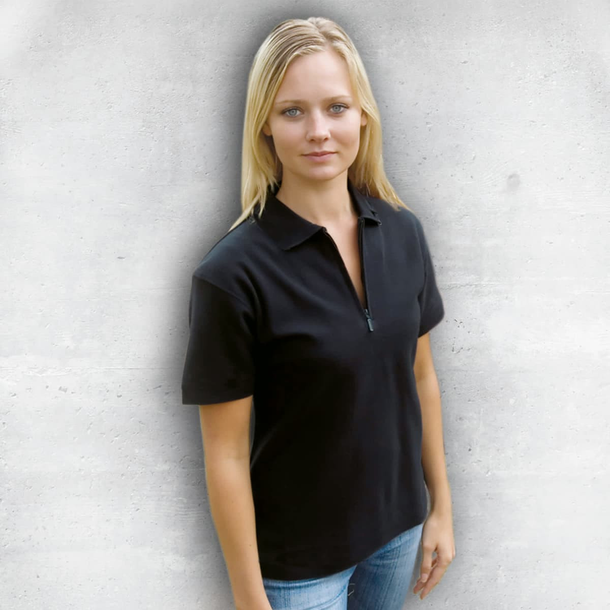 A black women's polo shirt with a zippered collar, featured on a model against a concrete background.