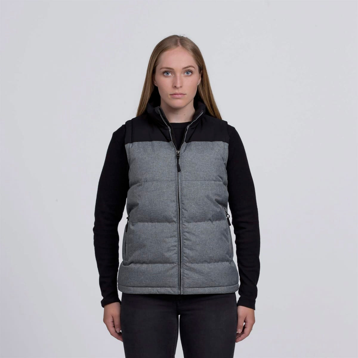 A grey and black puffa vest with a zip front and a logo, displayed on a model against a plain background.